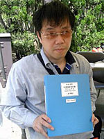 完成した点字版の「世田谷区災害時区民行動マニュアル」と大竹さん(防災フェアの会場で