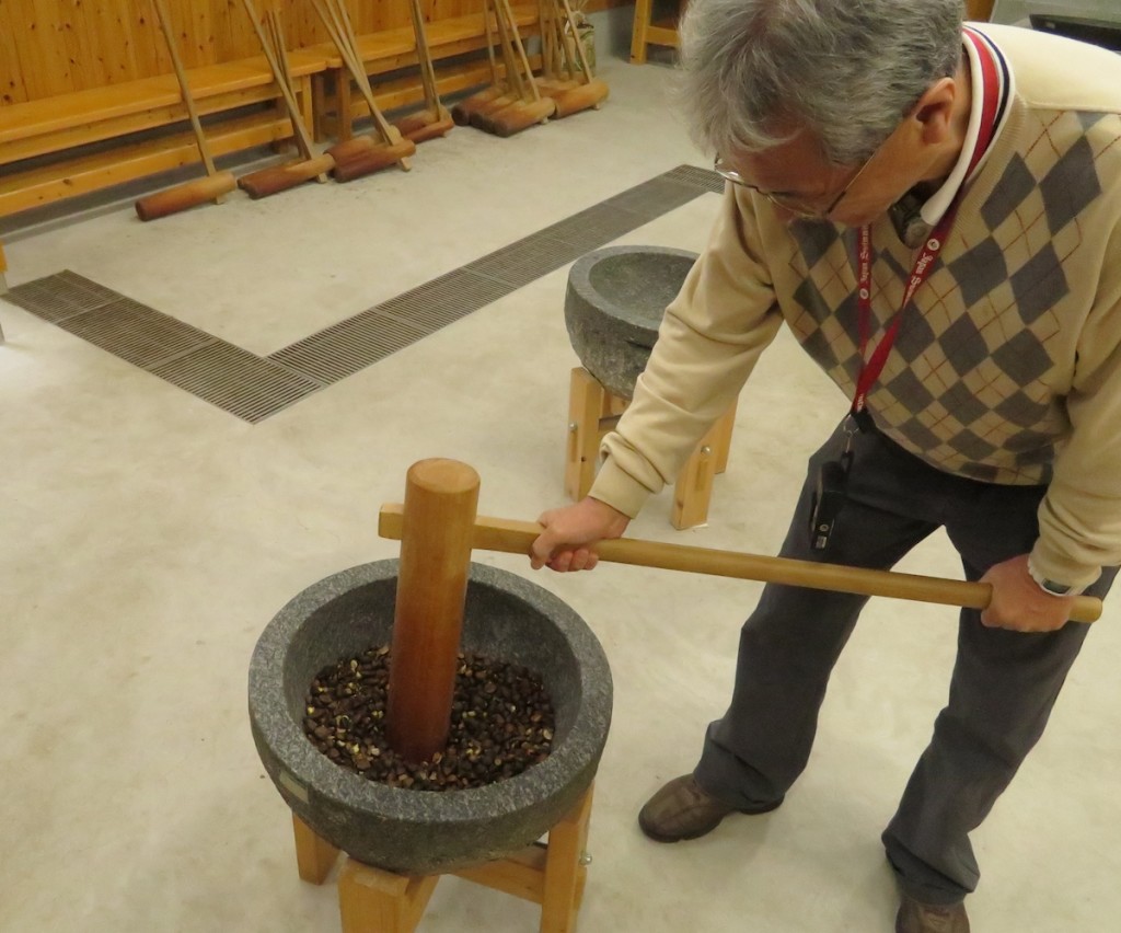 椿の実を石臼でつぶし、蒸したあと、圧搾機を使いながらも自分の力で搾りだす椿油作り