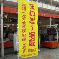 宅配をする店の前には旗が立っている村山団地